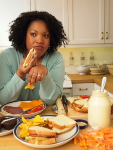 a woman snacking on lots of junk food at her kitchen table